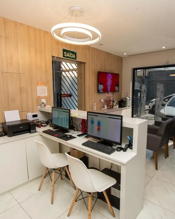 Recepção da Clínica Sorriclin, com o balcão de atendimento e a sala de espera