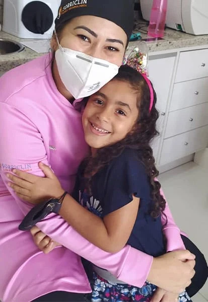 Menina abraçando a dentista depois da consulta